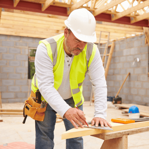 Carpenter measuring wood on construction site