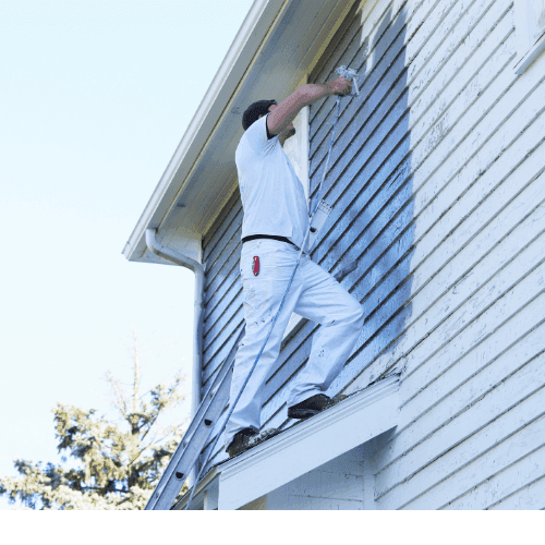 Painter on ladder painting house exterior